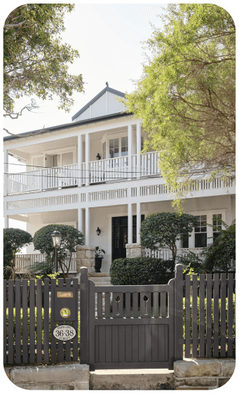 Painted weatherboard home with a dark picket fence in Sydney