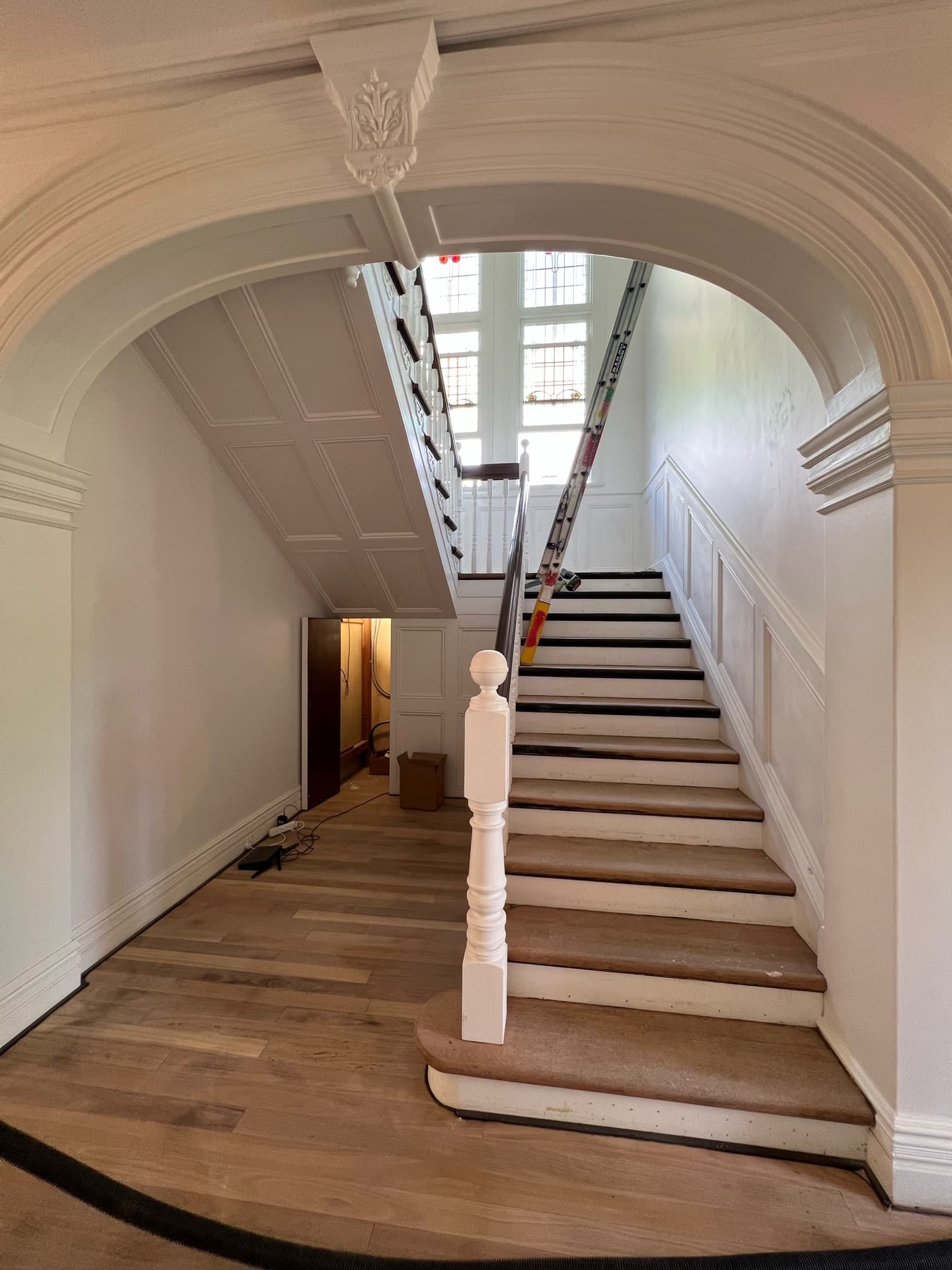 Repainted arched entry and timber staircase in a period home
